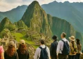 Turistas observan las ruinas de Machu Picchu con el Huayna Picchu al fondo.