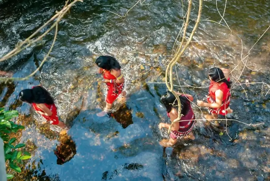 Mujeres de comunidades nativas caminando por un río en la Amazonía peruana